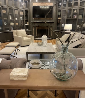 A living room with a fireplace, leather sofas, a coffee table, and a large vase.