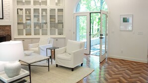 Un salón amplio con chimenea, muebles blancos y un armario grande.