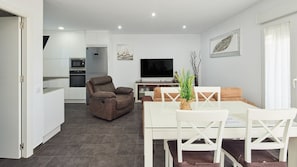 Relax in a comfortable living space with a reclining chair, dining area, flat-screen TV, and fully equipped kitchen.