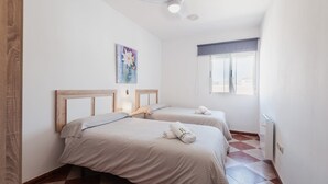 Ein Schlafzimmer mit zwei Betten, einem Fenster mit Blick und einem Gemälde an der Wand.