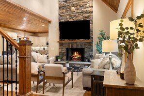 Cozy living area with a stone fireplace, comfortable seating, and a TV.