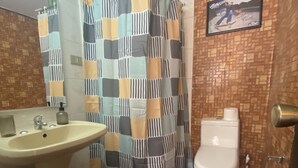 Een badkamer met een wastafel, toilet en douchegordijn.