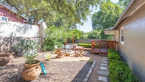 A backyard with a patio, seating area, and potted plants.