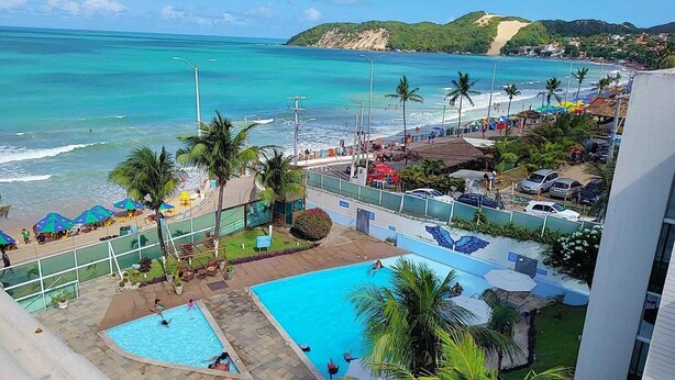Un resort con piscina, playa y vista al océano.