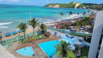 Resort com piscina, praia e vista para o oceano.