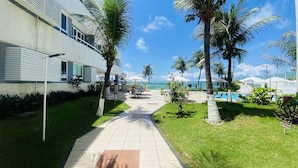 Un hotel con piscina, palmeras y vista al océano.