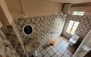 Bathroom features a checkered tile pattern, sink, mirror, toilet, and window.