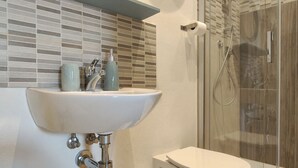 Ein Badezimmer mit Waschbecken, Toilette und Dusche.