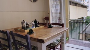 Een houten eettafel met stoelen, een koffiezetapparaat en een waterkoker op een dienblad.