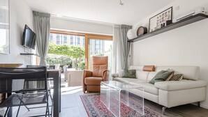 A modern living room with a sofa, a coffee table, a TV, and a chair.