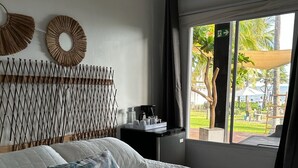 Habitació d'hotel amb un llit gran, una petita taula de nit amb una cafetera i vistes a l'exterior.