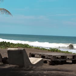 Na praia, areia preta, guarda-sóis