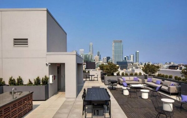 Enjoy the city view from our rooftop terrace, featuring a seating area, bar, and kitchen.