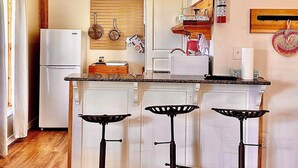 A kitchen with a refrigerator, stove, and bar stools. - Waterfront Two Bedroom Newly Built Cottage, Beach, Covered Deck, Firepits  (New Glasgow)