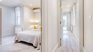 A bedroom with a bed, bedside lamp, and an air conditioning unit. - Marble Arch Suite 3-Hosted by Sweetstay (London)