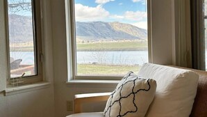 A room with a view of mountains and a lake through a large window. - Columbia River Waterfront with Private Dock near Gamble Sands Golf Course! (Brewster)