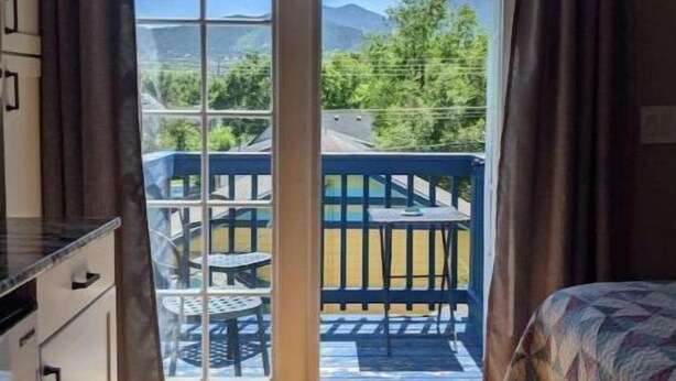 Un dormitorio con vista a una piscina y montañas.