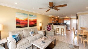 A spacious living room with a sofa, coffee table, and artwork on the wall.