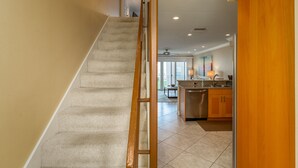 A staircase leading to a kitchen area with a view of the living room.