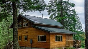 A wooden cabin with a metal roof, surrounded by trees. - Jenny Creek Cabin w/ Jacuzzi and Wood Stove at Green Springs Inn (Ashland)