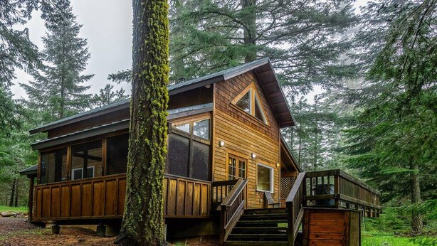 A cabin with a wooden exterior, large windows, and a staircase leading to a deck. - Hobart Peak Cabin w/ Jacuzzi and Wood Stove at Green Springs Inn (Ashland)