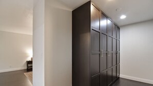 A hallway with a dark wooden wardrobe and a small table with a lamp. - The Charming Home with a Pool (Yuba City)