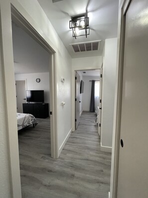 2 habitaciones, escritorio y tabla de planchar con plancha