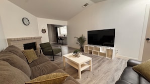 A living room with a fireplace, a television, a sofa, and a coffee table.