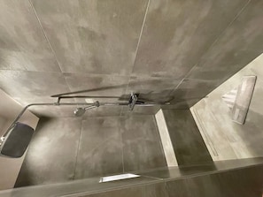 A modern bathroom with a shower, a toilet, and a towel rack.