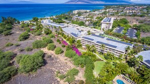 An aerial view of a resort with multiple buildings, a swimming pool, and a beach area.