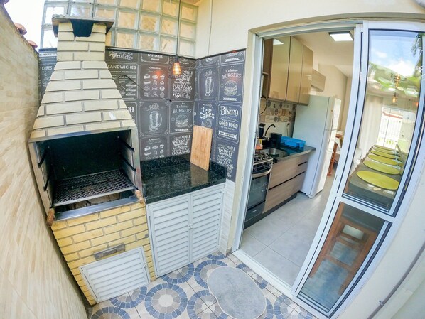 A compact kitchen with a built-in oven, a small countertop, and a sliding door leading to a dining area.