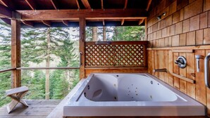 A wooden cabin with a large bathtub, wooden walls, and a view of trees. - Boccard Point Cabin w/ Jacuzzi and Wood Stove at Green Springs Inn (Ashland)