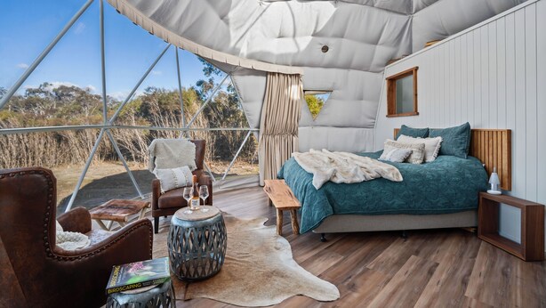 A tented accommodation with a bed, seating area, and a view of the outdoors. - Scribbly Farm Premium Dome Bush retreat Southern highlands (High Range)