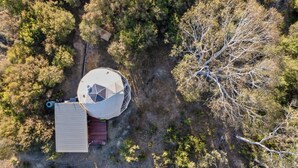 An aerial view of a property with a large cylindrical structure, a rectangular building, and a tree-lined area. - Scribbly Farm Premium Dome Bush retreat Southern highlands (High Range)