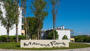 A sign for Marina Park with a modern building in the background. - Great and Spacious apartment overlooking the Swimming-Pool (Lagos)