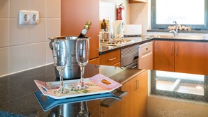 A kitchen with a countertop, a wine glass, a bottle of champagne, and a menu. - Great and Spacious apartment overlooking the Swimming-Pool (Lagos)