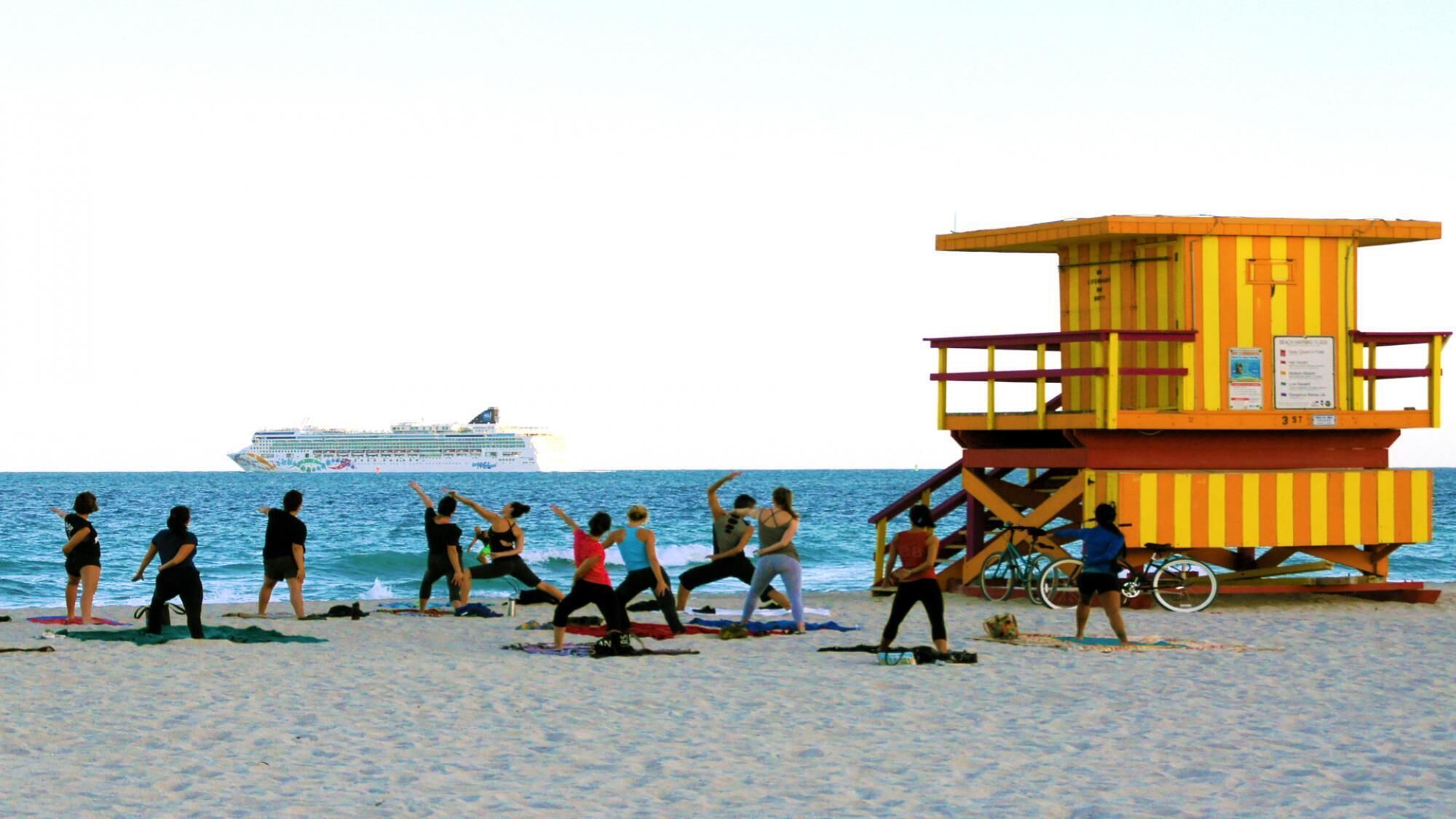 A lifeguard tower on a beach with a cruise ship in the background.