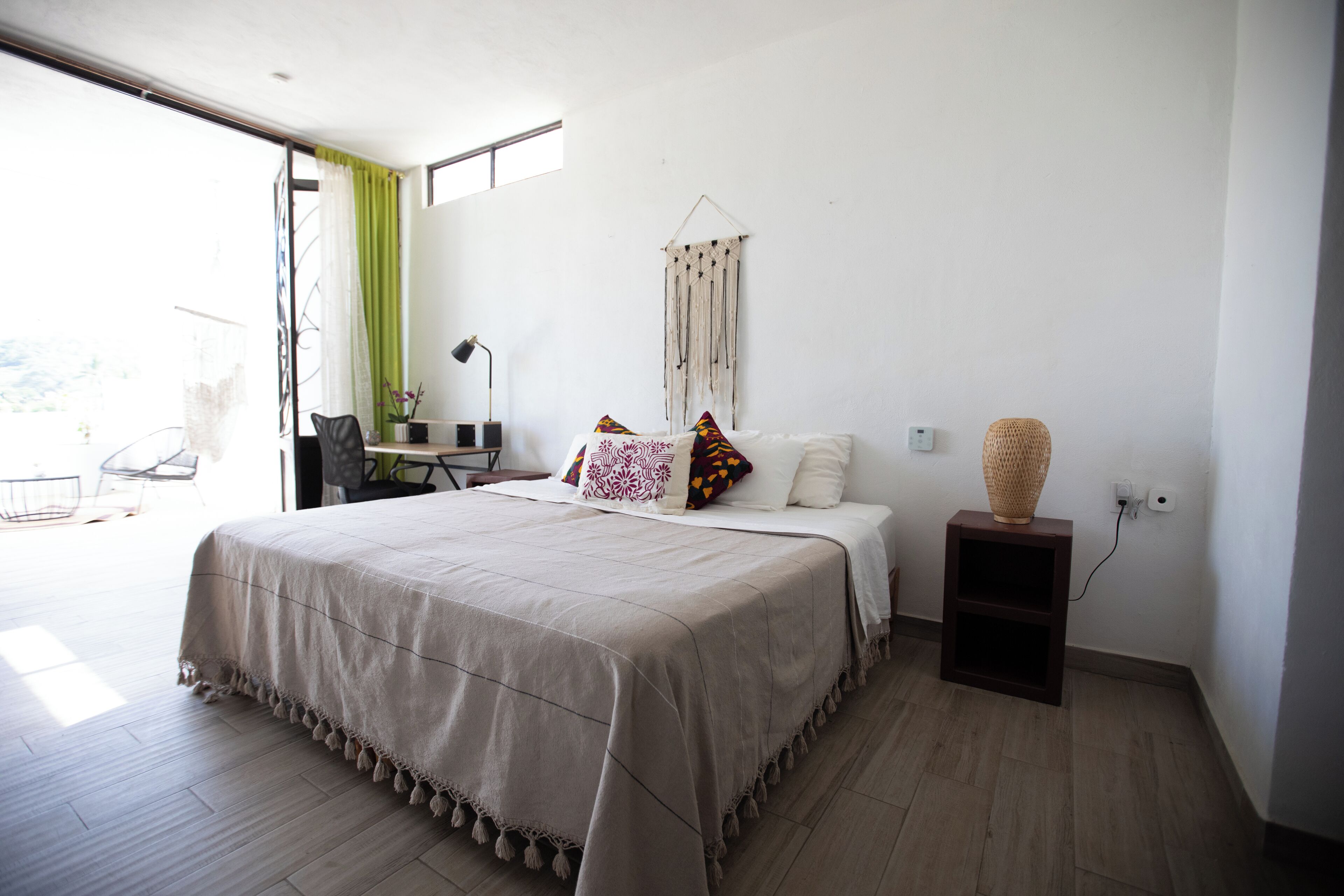 A modern bedroom with a large bed, a desk, and a chair.