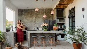 A modern kitchen with a concrete island, hanging pendant lights, and bar stools. - Casa Fénix - Sayulita (Sayulita)