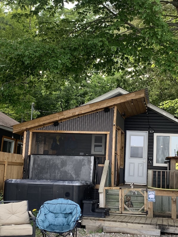 Relax on the porch with a soothing view of the surrounding woods, featuring a hot tub.