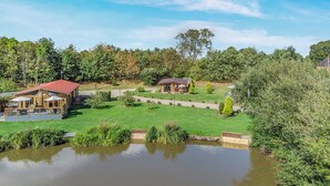 A lakeside property with a wooden cabin, a gazebo, and a well-maintained lawn. - 2 bedroom accommodation in Ellesmere (Ellesmere)