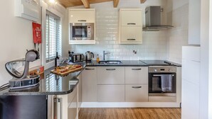 A modern kitchen with a microwave, toaster, kettle, and a sink. - 2 bedroom accommodation in Ellesmere (Ellesmere)