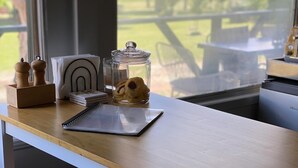 A wooden table with a notebook, a glass jar with cookies, and a salt shaker.