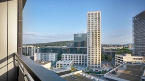Ein modernes Hochhaus mit einer gitterförmigen Fassade, umgeben von weiteren zeitgenössischen Gebäuden.