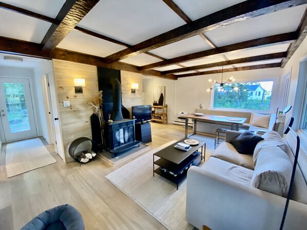 Cozy living room with a fireplace, comfortable sofa, and dining area.