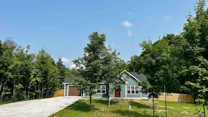 Een woonhuis met een oprit die leidt naar een huis met een garage.