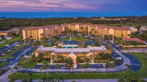 A large hotel with multiple buildings, a parking lot, and a pool area. - Jupiter Bay Resort Condo, steps to the beach! Comfortably sleeps family of 4! (Jupiter)