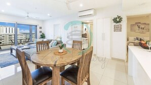A modern apartment with a dining area, kitchen, and living space. - Zen Sun City - 2 BR Cozy Apt Ocean View (Darwin)