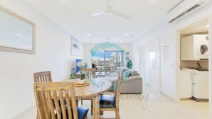 A modern apartment with a dining area, living room, and kitchen. - Zen Sun City - 2 BR Cozy Apt Ocean View (Darwin)