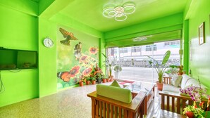 A room with a green color scheme, wooden furniture, and a large window with a view of the street. - Chunfa B&B (Huxi)